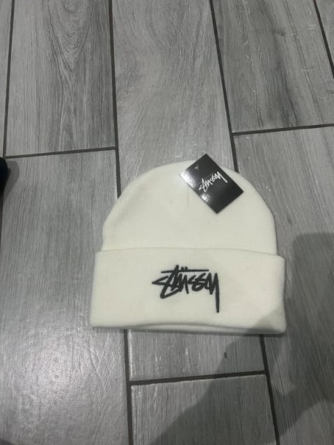 Biała czapka stussy.