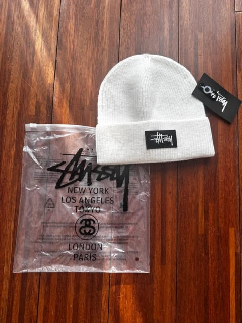 Biała czapka stussy